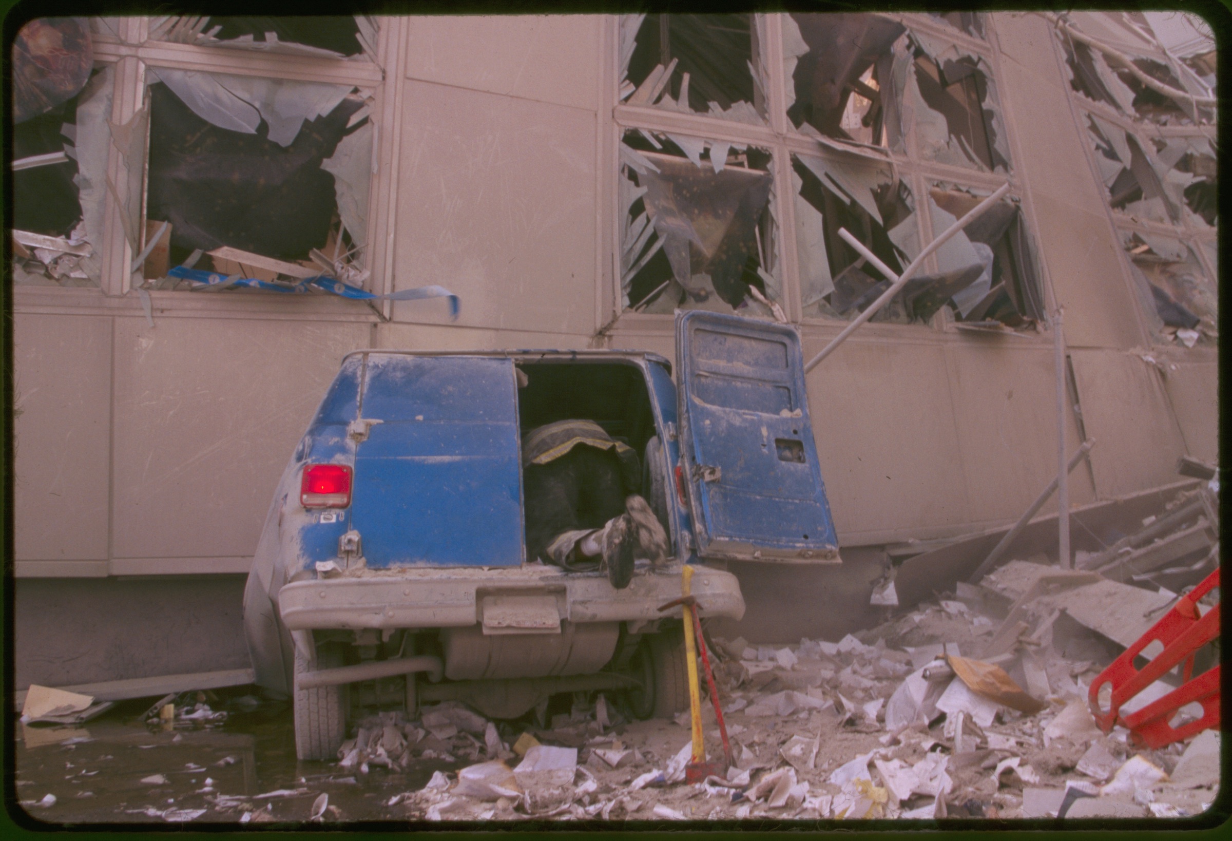 Rescue worker checking inside the back of a van amid debris following September 11th terrorist attack on World Trade Center, New York City